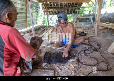 NUSA PENIDA, INDONÉSIE - Juillet 9 : deux hommes non identifiés à un groupe de travail bois boutique sur Nusa Penida, Indonésie le 9 juillet 2017. Banque D'Images