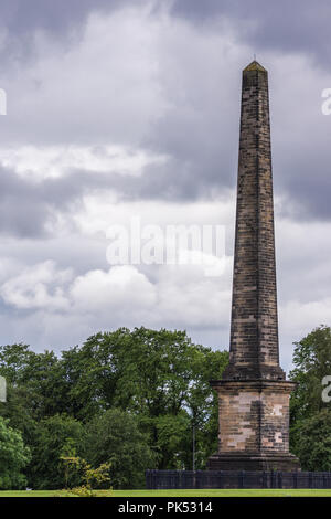Glasgow, Scotland, UK - 17 juin 2012 : Le Monument Nelson est en brique obélisque sur Glasgow Green sous heavey cloudscape. Feuillage vert. Banque D'Images