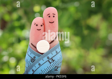 Doigts art de l'heureux couple. Le concept d'un homme et une femme sur la pilule pour la perte de poids. Banque D'Images