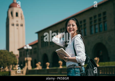 Smart et belle asiatique student holding son livre et son rêve de visiter l'université. Banque D'Images