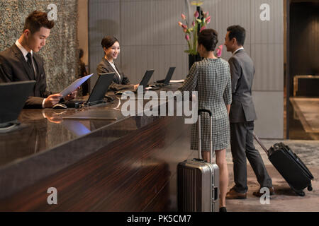 Couple checking into hotel Banque D'Images