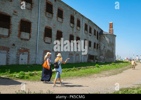 La prison de Patarei, un après-midi d'été, deux jeunes femmes marchent devant le bâtiment abandonné et délicté de la prison de Patarei dans la baie de Kalamaja, à Tallinn, en Estonie. Banque D'Images