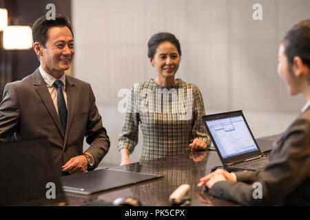 Couple checking into hotel Banque D'Images