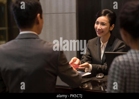 Couple checking into hotel Banque D'Images