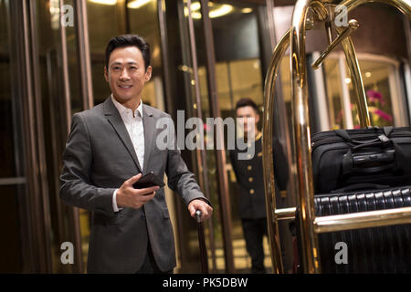 Cheerful businessman in hotel lobby Banque D'Images