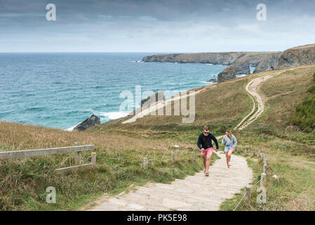 Les vacanciers grimpant suit sur le South West Coast Path au Bedruthan Steps sur la côte nord des Cornouailles. Banque D'Images