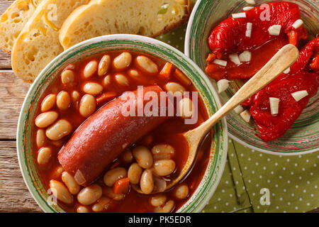 Soupe de haricots avec de la saucisse servie avec le poivron et l'ail mariné close-up en sur la table supérieure horizontale. Vue de dessus Banque D'Images