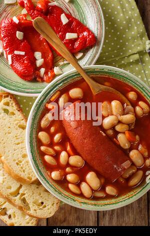 Soupe de haricots avec de la saucisse servie avec le poivron et l'ail mariné close-up en sur la table. Haut Vertical Vue de dessus Banque D'Images