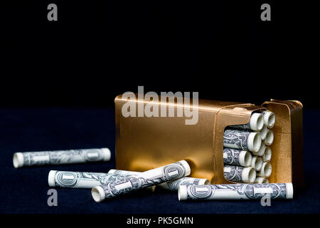 Notion de droit de fumer des cigarettes, coûte beaucoup d'argent. Dollar bills enroulé comme si elles sont les cigarettes. Boîte à cigarettes en or Banque D'Images