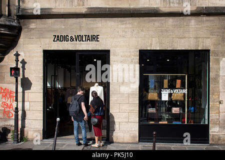 Un couple regarde une robe à la fenêtre de la marque fashion store dans Le Marais Paris. 3ème arrondissement Banque D'Images