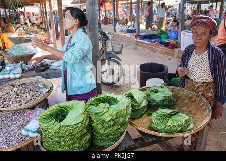 Les clients et les vendeurs interagissent dans un stand de légumes d'un marché local. Bagan, Myanmar (Birmanie). Banque D'Images