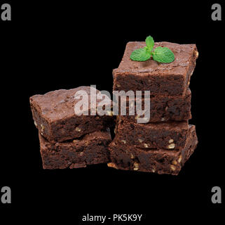 Pile de pièces au four carrés de chocolat tarte brownie aux noix isolé sur un fond noir Banque D'Images