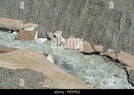 Un glacier stream traverse vieux ponts de neige dans les montagnes. Banque D'Images