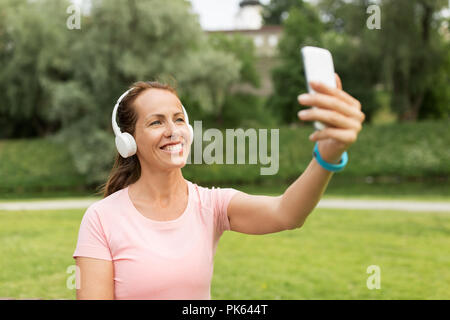 Femme en directe prend en selfies smartphone à park Banque D'Images