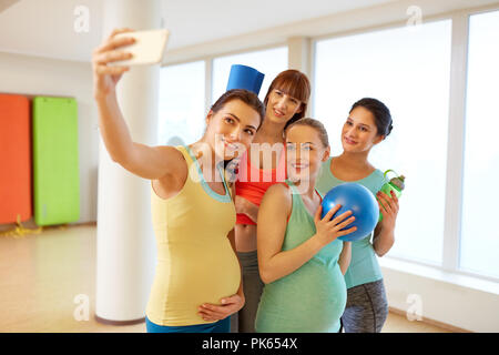 Les femmes enceintes prenant en selfies smartphone dans une salle de sport Banque D'Images