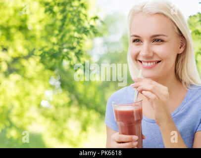 Smiling woman drinking juice ou secouer Banque D'Images