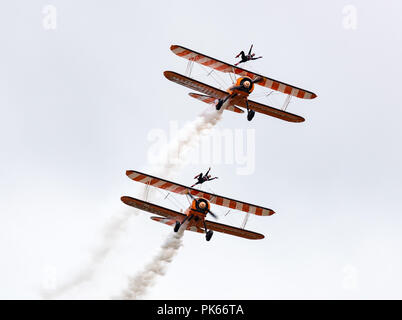 Aile AeroSuperBatics marcheurs de l'Flying Circus lean à un angle au sommet de leur précaire biplans Boeing Stearman Banque D'Images