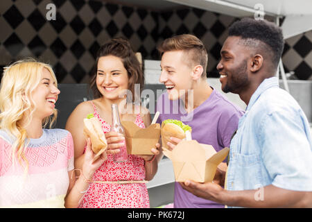 Happy friends avec boissons manger au camion alimentaire Banque D'Images