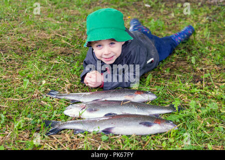 Quatre ans avec ses trois grosses truites arc-en-ciel le poisson, Meon Springs pêche à l'omble, East Meon, Hampshire, Angleterre, Royaume-Uni. Banque D'Images