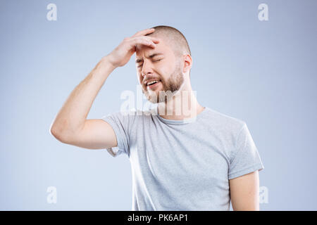 Belle homme audacieux mettant sa main sur le front Banque D'Images