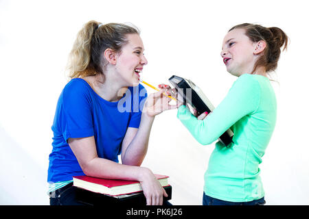 Deux jolies filles préadolescentes avoir du plaisir ensemble. Conversation sur des téléphones portables, des secrets entre amis, des commérages, blowing kisses sont quelques-unes de ces images posées. Banque D'Images