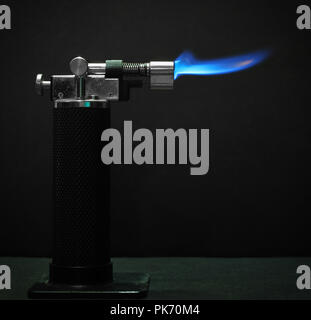 Torche micro contre un fond sombre avec une flamme bleue Banque D'Images