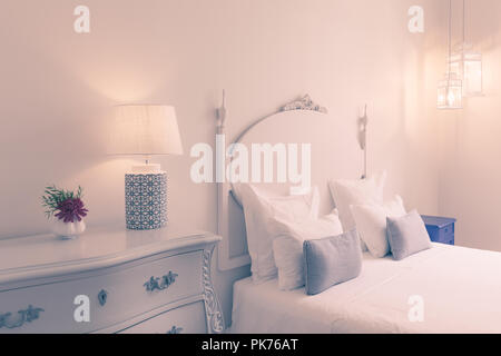 Blanc fantaisie élégante chambre avec un lit double, lampe, fleur Banque D'Images