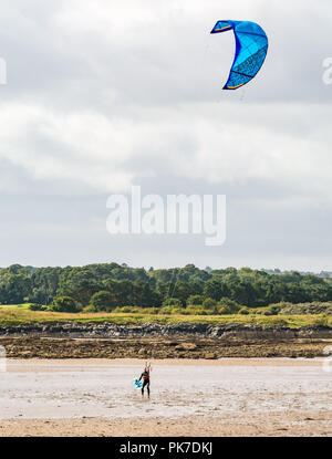 Longniddry Bents, East Lothian, Scotland, UK, 11 septembre 2018. Météo France : 40 mph winds sur une journée ensoleillée de créer de bonnes conditions pour le kite surfers dans le Firth of Forth. Un kite surfer a du mal à tenir sur un cerf-volant dans le vent fort en portant de nouveau sur la plage Banque D'Images