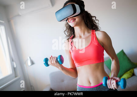 Jeune femme faisant des exercices portant des lunettes vr Banque D'Images