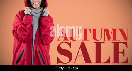 Portrait of woman in hooded jacket standing against white background Banque D'Images