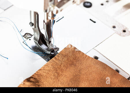 Morceau de cuir et le pied presseur de la machine à coudre industrielle close up Banque D'Images