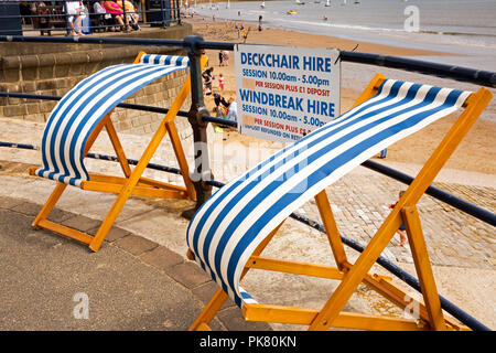 Royaume-uni, Angleterre, dans le Yorkshire, Filey, Coble Landing, location de chaises longues à rayures dans le vent Banque D'Images