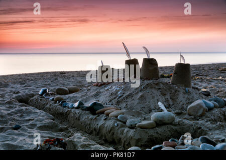 Châteaux de sable sur la plage de Sandsend beach juste avant le lever du soleil, près de Whitby sur la côte du Yorkshire du Nord, Angleterre. Banque D'Images