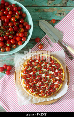 Tart, tarte ou gâteau au fromage avec du fromage cottage et les tomates et tomates fraîches sur un fond de bois. Focus sélectif. Banque D'Images