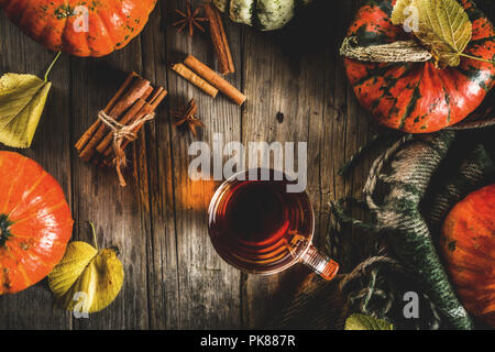 Citrouille épicée thé, boisson chaude d'automne coupe de verre, avec des citrouilles, de cannelle et d'épices sur fond de bois rustique vieux copy space Banque D'Images