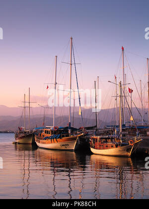 Coucher du soleil à Fethiye avec assez traditionnel'gulet bateaux ancrés dans l'eau calme Banque D'Images