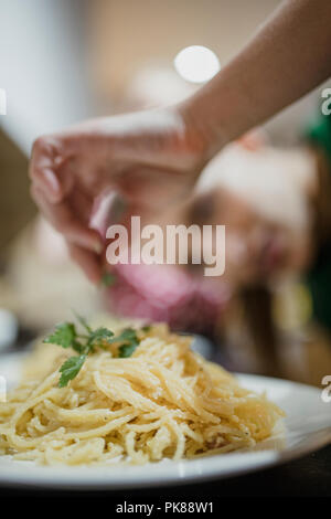 Rapprochée sur des spaghetti carbonara avec de la coriandre est ajouté sur le dessus. Banque D'Images