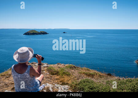 Dame regardant la mer de prendre une photographie sur son téléphone portable Black Rock Solva Haverfordwest Pembrokeshire Wales Banque D'Images