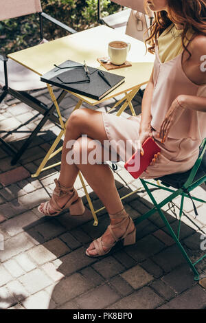 Vue partielle de businesswoman sitting at table with notebook in cafe Banque D'Images