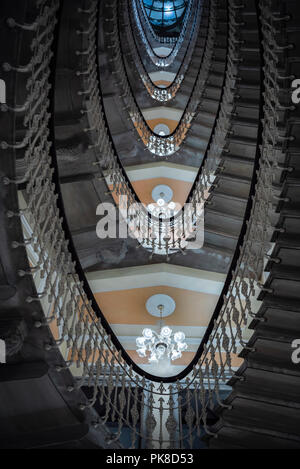 Escaliers sophistiqué avec des lustres à chaque étage, vue d'en bas, comme un modèle de figures géométriques, ovale dans un hôtel à Gênes, en Italie. Banque D'Images