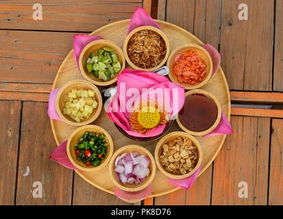 Envelopper d'une bouchée avec red lotus petal (Haspres Kam) qu'isThai et le Laos est snack traditionnel sur la table en bois Banque D'Images