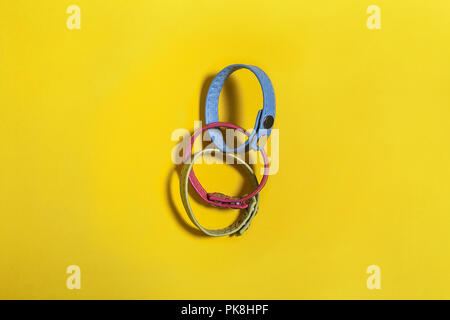 Ensemble de trois bracelets main ceinture multicolore étendu sur un fond jaune. espace libre pour le texte de la publicité Banque D'Images
