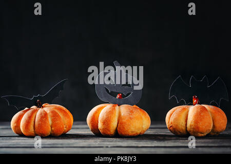 Des gâteaux d'halloween en forme de citrouille sur fond sombre. Hallooween sweets Banque D'Images