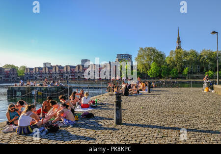 Shadwell Basin, Londres, UK - 7 mai 2018 : jeunes appréciant le soleil et les bains de soleil sur le quai du bassin de Shadwell. Banque D'Images