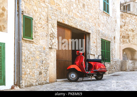 Vintage red scooter stationné dans un village historique espagnol Banque D'Images
