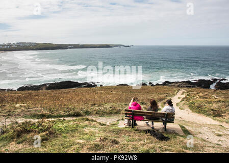 Des gens assis sur un banc sur la tête de Towan, surplombant la baie de Fistral Newquay en Cornouailles. Banque D'Images