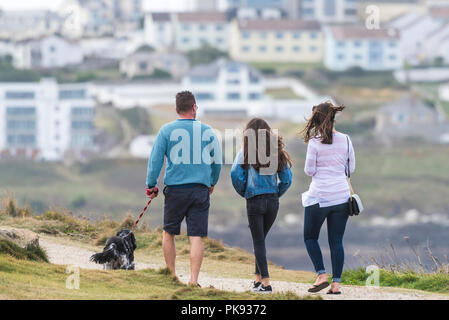 Une famille et leur chien marcher sur la Pointe à Newquay Cornwall. Banque D'Images