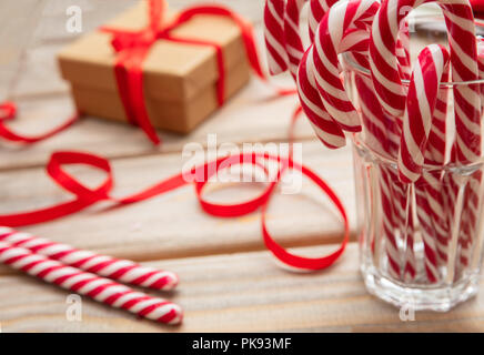 Le temps de Noël. Des cannes de bonbon dans un verre, fond en bois Banque D'Images