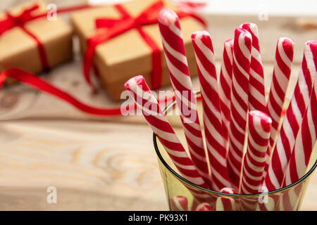 Le temps de Noël. Des cannes de bonbon dans un verre, fond en bois Banque D'Images