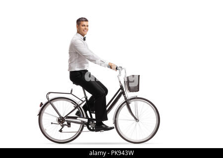 Beau jeune homme dans un tux de la bicyclette isolé sur fond blanc Banque D'Images